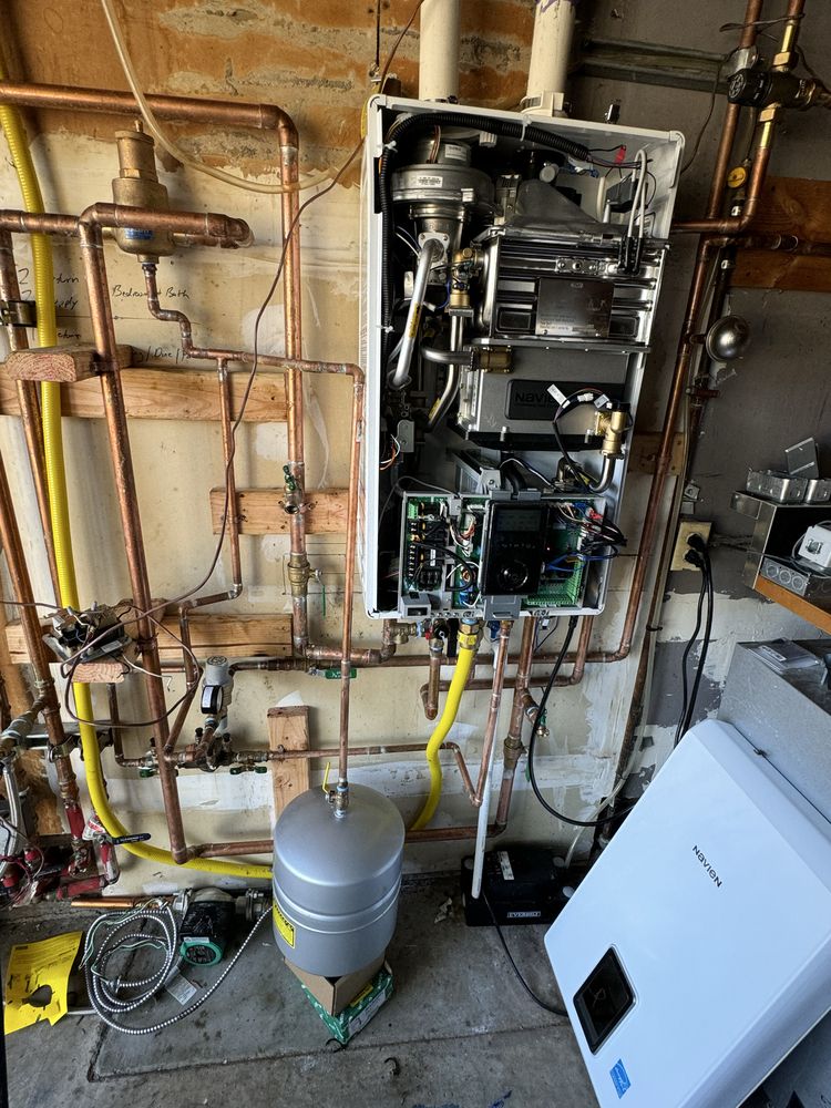 Tankless water heater with access panel open during commercial installation